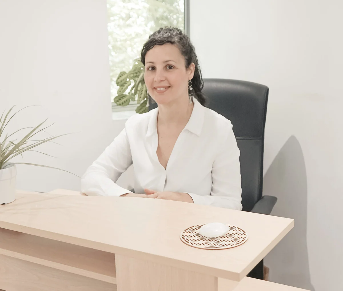 Aracelys Lopez, souriante et assise à son bureau au cabinet